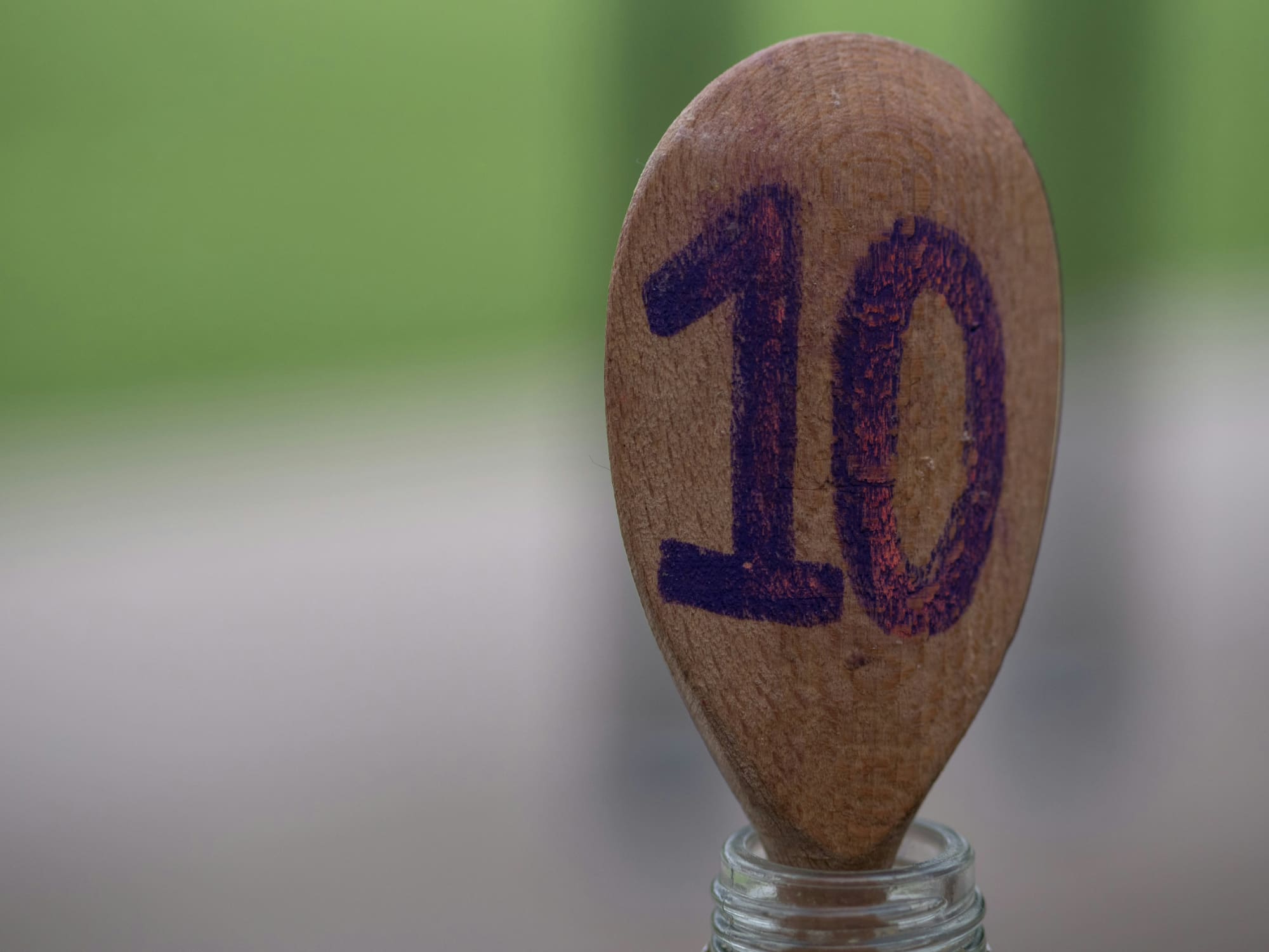 Ping pong racket resting in glass bottle with number 10 written on it