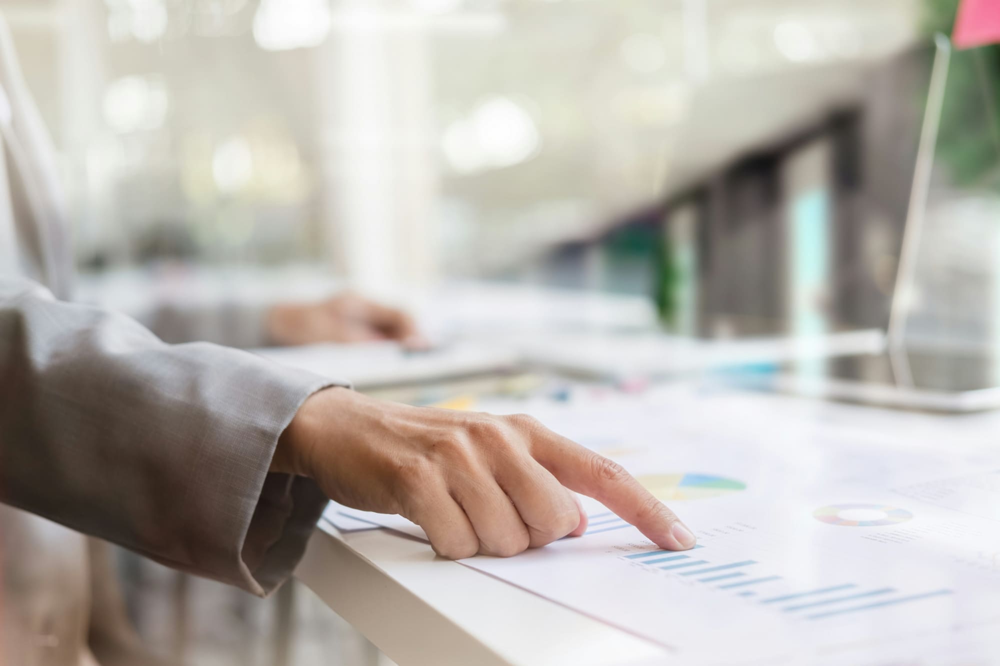 Person using finger to point to particular list on a paper document.